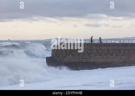 Brighton, East Sussex. 27 décembre 2020. Météo Royaume-Uni. Les vestiges de la tempête Bella battent la côte sud avec d'énormes vagues qui s'écrasent sur le front de mer de Brighton devant des spectateurs audacieux. Le bureau met a émis des avertissements météorologiques à travers le Royaume-Uni en raison de vents violents et d'inondations. Credit: Francesca Moore/Alamy Live News Banque D'Images