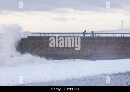 Brighton, East Sussex. 27 décembre 2020. Météo Royaume-Uni. Les vestiges de la tempête Bella battent la côte sud avec d'énormes vagues qui s'écrasent sur le front de mer de Brighton devant des spectateurs audacieux. Le bureau met a émis des avertissements météorologiques à travers le Royaume-Uni en raison de vents violents et d'inondations. Credit: Francesca Moore/Alamy Live News Banque D'Images