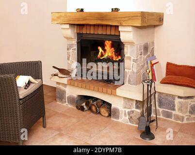 Calme et chaleur du feu dans un foyer en pierre et en bois. Banque D'Images