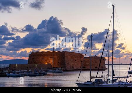 Lever du soleil au vieux port d'Héraklion, sur l'île de Crète, en Grèce, en Europe. La forteresse vue est Koules (Kules), l'ancien château vénitien également connu sous le nom de Roca a Mare Banque D'Images