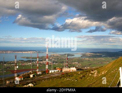 Mâts radio et antennes tv rouges et blancs et vue depuis le sommet de la colline de Pena Cabarga Santander Cantabria Espagne Banque D'Images