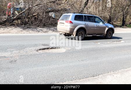 Les grands nids-de-poule profonds sont un exemple de mauvais entretien des routes Banque D'Images