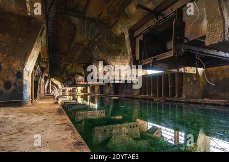 Ancienne usine industrielle avec bunkers de charbon et cave remplie de eau toxique Banque D'Images