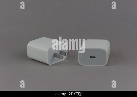 Adaptateur secteur blanc USB-C de 20 watts, avant et arrière, sur fond gris Banque D'Images