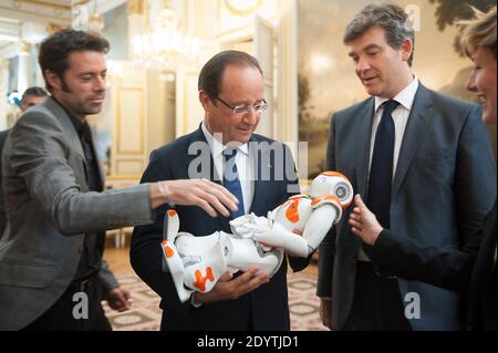 Le président français François Hollande est détenteur d'un robot humanoïde Nao de la société Aldebaran Robotics lorsqu'il visite une exposition sur le design et la technologie industriels français à l'Elysée Palace de Paris, France, le 12 septembre 2013. Chez R, ministre français de la reprise industrielle Arnaud Montebourg. Photo de Thierry Orban/ABACAPRESS.COM Banque D'Images