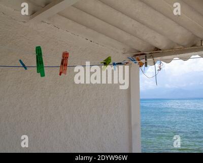 Pinces à linge sur la ligne de lavage avec vue sur la mer à Roda, Corfou, Grèce Banque D'Images