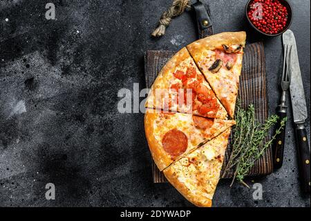 Ensemble de différentes tranches de pizza. Arrière-plan noir. Vue de dessus. Copier l'espace Banque D'Images