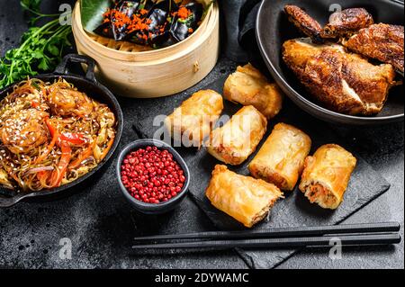 Plats chinois, fond noir. Nouilles chinoises, boulettes, canard de pékin, dim sum, rouleaux de printemps. Célèbre. Vue de dessus Banque D'Images