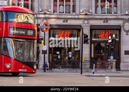 Londres, Royaume-Uni. 27 décembre 2020. La boutique H&M est fermée sur la photo et le célèbre Red bus londonien est stationné à Oxford Street. Sous les restrictions de niveau 4, les pubs et les restaurants ferment, ainsi que les magasins « non essentiels ». Crédit : SOPA Images Limited/Alamy Live News Banque D'Images