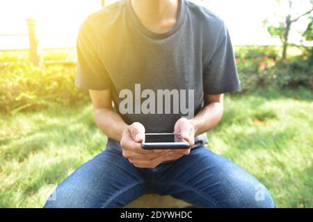 Homme tenant un smartphone mobile à l'aide d'une application intelligente par Internet en ligne Banque D'Images