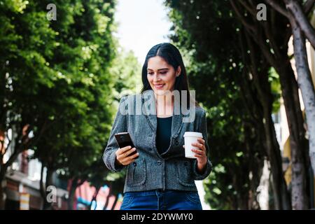 Portrait d'une femme d'affaires latine marchant dans la rue de une ville coloniale en amérique latine Banque D'Images