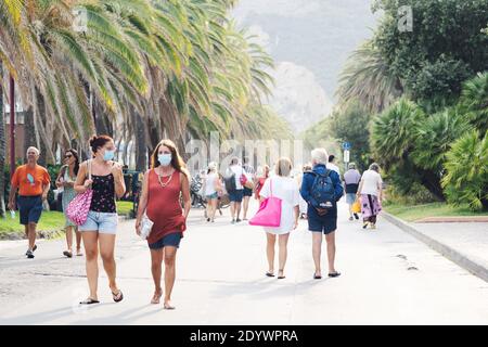 Les personnes marchant le long de la plage portant des masques protecteurs ou médicaux. Nouvelle norme en Italie. Italie - août 2020 Banque D'Images