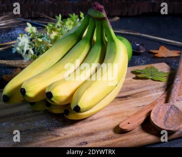 un bouquet de bananes fraîches et mûres sur une table en bois Banque D'Images