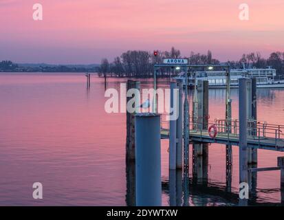 Coucher de soleil coloré sur le lac, vue romantique de la jetée vide.Arona, Piémont, lacs italiens, Italie. Banque D'Images