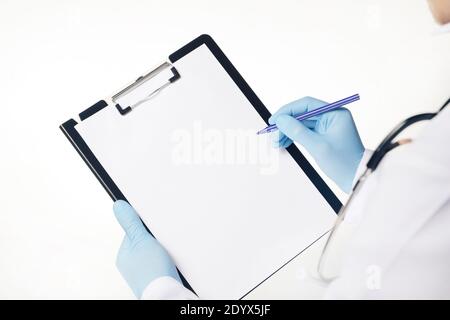 Médecin dans des gants en latex bleu tenant une presse-papiers médicale avec une feuille de papier vierge vide. Concept de soins de santé et de médecine. Vider le modèle de presse-papiers et l'espace de copie. Isolé sur fond blanc. Banque D'Images