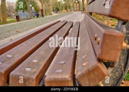 Chaise de rue de style ancien et rétro en bois avec feuilles séchées au sol et thème de l'automne. Banque D'Images