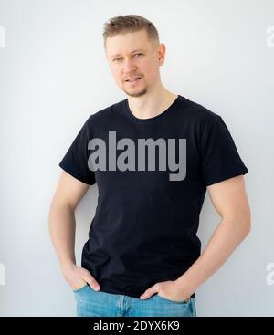 Beau homme posant dans un t-shirt noir vierge Banque D'Images