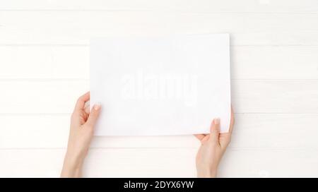 Mains tenant le papier blanc vierge format a4 pour le design Banque D'Images