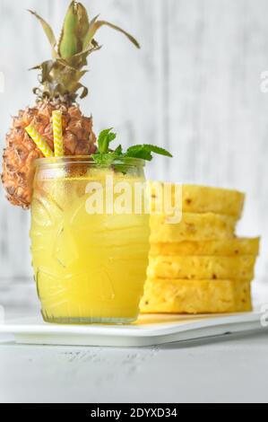 Verre d'ananas de style tiki sur fond blanc Banque D'Images