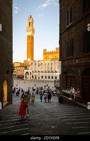 Jeune couple prenant une photo de selfie sur le fond de la Torre del Mangia, Palazzo Publico à la Piazza del Campo, Sienne, Toscane, Italie Banque D'Images