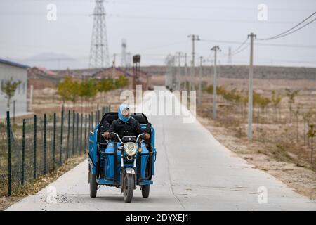 (201228) -- YINCHUAN, 28 décembre 2020 (Xinhua) -- Li Yaomei est sur le chemin de l'usine de balais dans le village de Longyuan, district de Hongsibao, dans la ville de Wuzhong, région autonome de Ningxia hui, dans le nord-ouest de la Chine, le 27 octobre 2020. Xihaigu, une région en grande partie montagneuse du centre-sud de Ningxia, a été une fois infligée par une pauvreté profonde et a marqué le « lieu le plus inadapté pour les établissements humains » par les Nations Unies dans les années 1970 en raison de la remise en état des terres, de la sécheresse et d'un environnement écologique fragile. Le 16 novembre 2020, Xihaigu a toujours fait ses adieux à la pauvreté absolue, au cours de laquelle 'le pouvoir' a joué un rôle de dispensab Banque D'Images