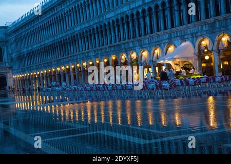 Venise, Italie - 22 juin 2014 : des eaux d'inondation s'inpénètrent dans un espace salon vide d'un restaurant situé sur la Piazza San Marco au coucher du soleil. La ville récemment Banque D'Images