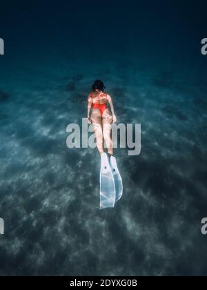 La femme libre plongée sous l'eau avec des nageoires blanches. Plongée libre d'été avec femme attrayante dans l'océan Banque D'Images
