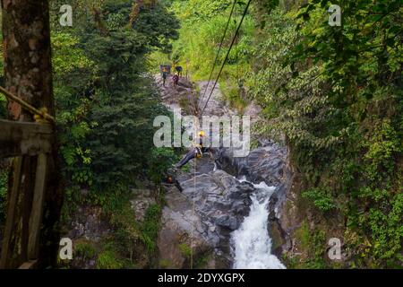 Une jeune femme qui monte sur une corde de tyrolienne dans une jungle d'aventure extrême à Xico, Veracruz, Mexique Banque D'Images