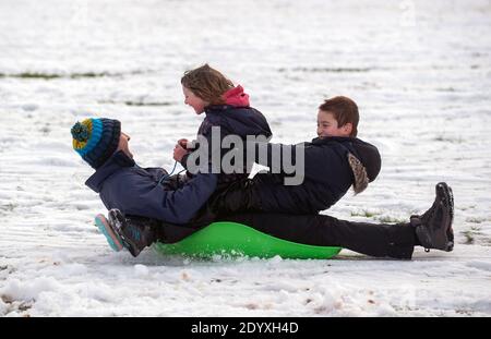 Des gens qui traînent dans la neige dans un parc à Newcastle-Under-Lyme, Staffordshire. Banque D'Images