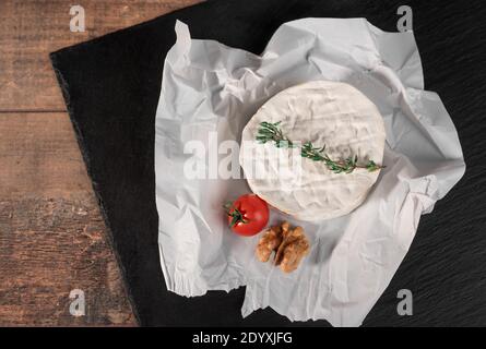 Délicieux fromage brie sur fond noir. Type de fromage Brie. Camembert. Du fromage Brie frais et une tranche sur le plateau en pierre. Italien, fromage français. Banque D'Images