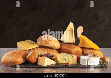 fromage et pain. nombreux types de pain et de fromage sur fond brun. plateau de fromages, dégustation et jumelage. Un assortiment de différents types de fromage, f Banque D'Images