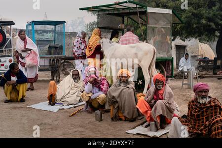 Groupe de personnes hindoues, certains mendiants à la recherche d'aumônes, femme vendant du thé, vache sainte, et d'autres près de la rivière Yamuna à Vrindavan, Uttar Pradesh, Inde. Banque D'Images