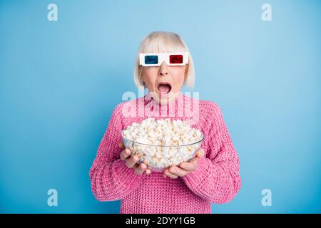 Photo portrait de la vieille femme terrifiée regardant un film d'horreur tenue bol à pop-corn isolé sur fond bleu pastel Banque D'Images