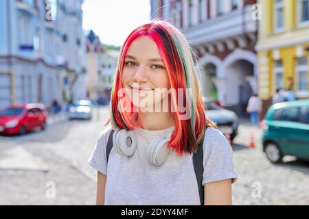 Très tendance, cette jeune fille est équipée d'un casque sans fil aux couleurs vives coiffure colorée Banque D'Images