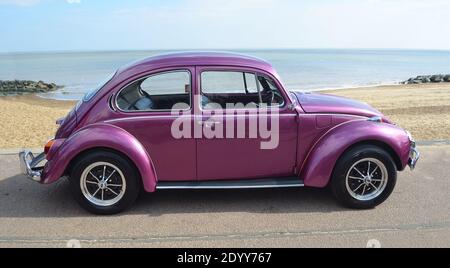 Voiture automobile classique Purple VW Beetle stationnée sur la promenade en bord de mer. Banque D'Images