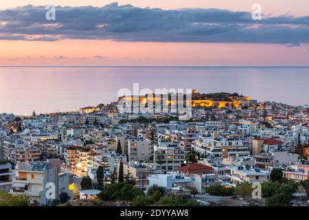 Vue panoramique de Réthymnon illuminée au crépuscule, montrant la vieille ville, le château de Fortezza, et vue sur la mer, Crète, Grèce Banque D'Images