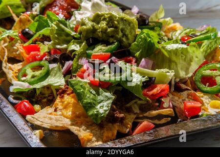 Garniture chargée de nachos de boeuf avec de la crème sure de guacamole et de la tomate salsa Banque D'Images