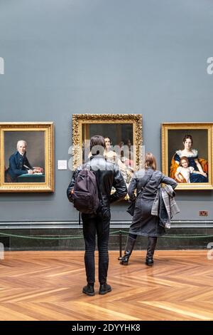 Visiteurs regardant des peintures à la National Gallery, Londres, Royaume-Uni Banque D'Images