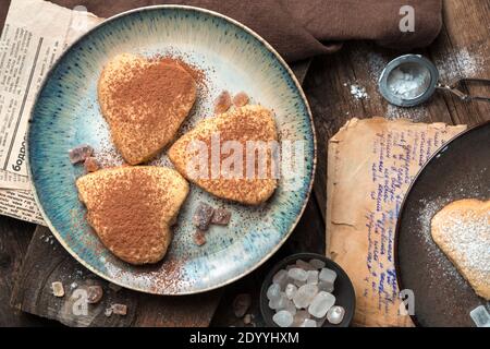 Arrière-plan culinaire avec des biscuits en forme de coeur sur fond vintage. Banque D'Images