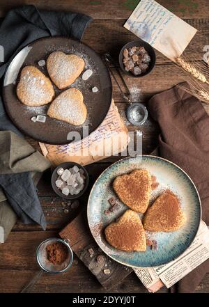 Biscuits en forme de cœur saupoudrés de cacao et de sucre en poudre. Banque D'Images