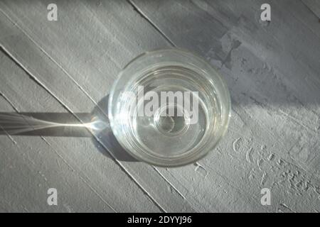 verre d'eau sur fond gris avec lumière abstraite et ombres Banque D'Images