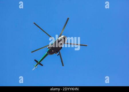 Hélicoptère volant contre le ciel bleu, avion à voilure tournante volant pour le transport Banque D'Images