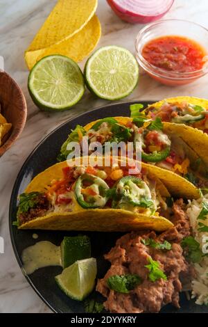 Tacos de bœuf mexicain avec grains de riz réfrits tortilla chips et garnitures diverses Banque D'Images