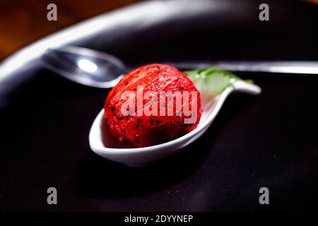 Photo macro rouge pitaya dans une plaque noire avec un argent fourche Banque D'Images