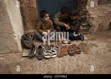 MAROC /Essaouira travail des enfants, /enfants vendant des vieilles chaussures dans la Médina ,Vieille ville . Banque D'Images