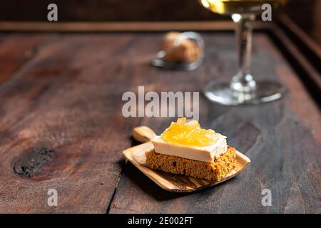 Pain d'épice grillé au foie gras et oignon confits et un verre de champagne sur fond sombre Banque D'Images