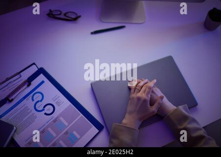 Photo de haut en bas d'une employée de bureau méconnue assise au bureau fin de la journée de travail tard dans la nuit Banque D'Images