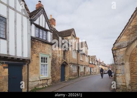 Un couple âgé se promène dans le village historique et bien conservé de Lacock, dans le comté de Wiltshire. Banque D'Images