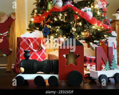 Train en bois et cadeaux sous un arbre de Noël Banque D'Images