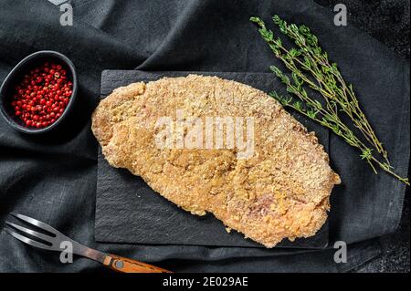 Weiner Schnitzel allemand, cru et fait maison. Arrière-plan noir. Vue de dessus Banque D'Images